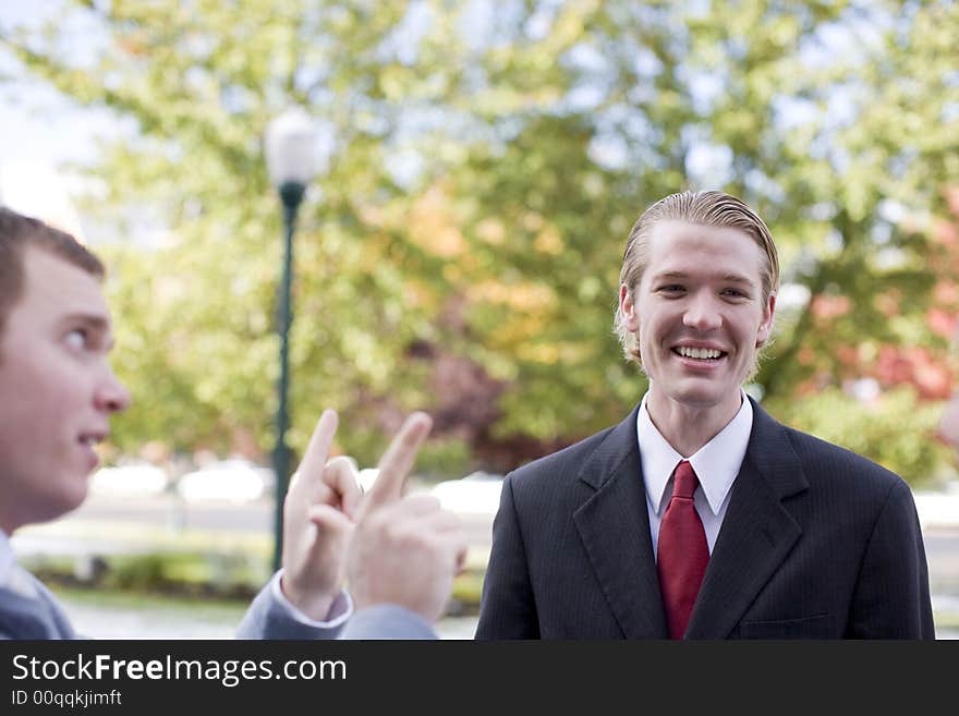 Side view of businessman talking with another businessman who is laughing. Side view of businessman talking with another businessman who is laughing