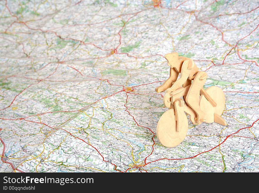 Wooden model of bicyclist on background of map. Wooden model of bicyclist on background of map