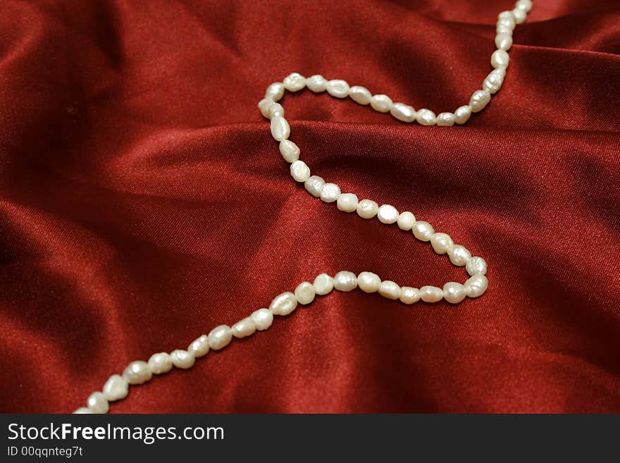 Beautiful pearls on red silk