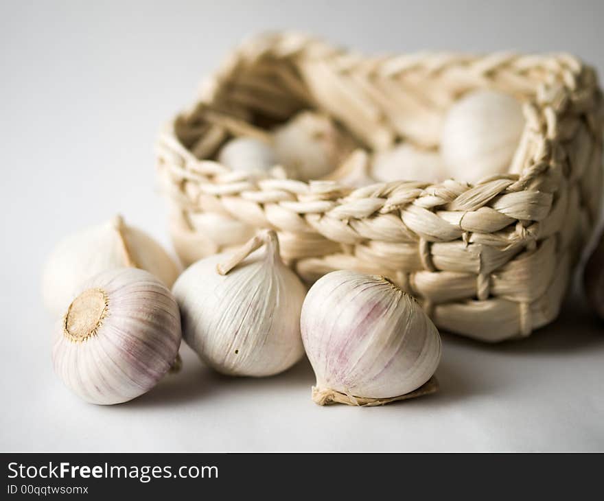 Still life of some garlic and a pale yellow weaved rectangular basket. Still life of some garlic and a pale yellow weaved rectangular basket