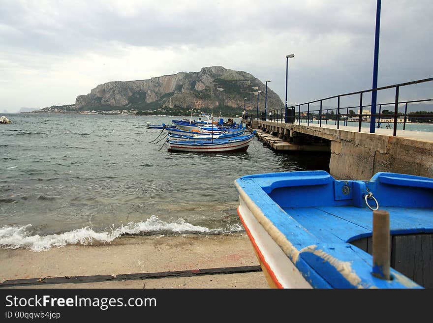 Colorful Sicilian boats on the dock in the port of Mondello, near Palermo. Coast line and beach. Sicily - Italy. Colorful Sicilian boats on the dock in the port of Mondello, near Palermo. Coast line and beach. Sicily - Italy