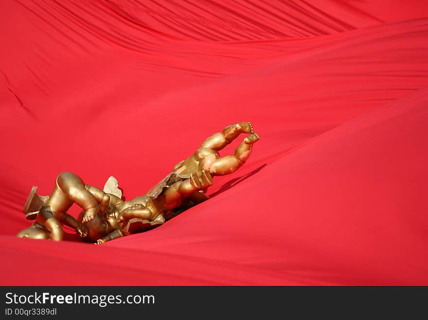 The image of gold angels on a red background. The image of gold angels on a red background