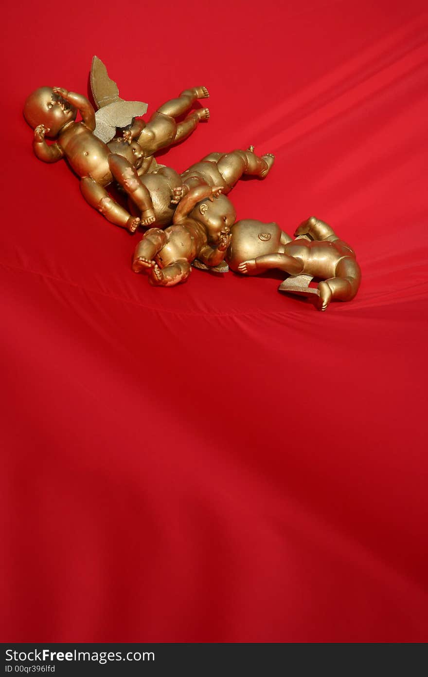 The image of gold angels on a red background. The image of gold angels on a red background