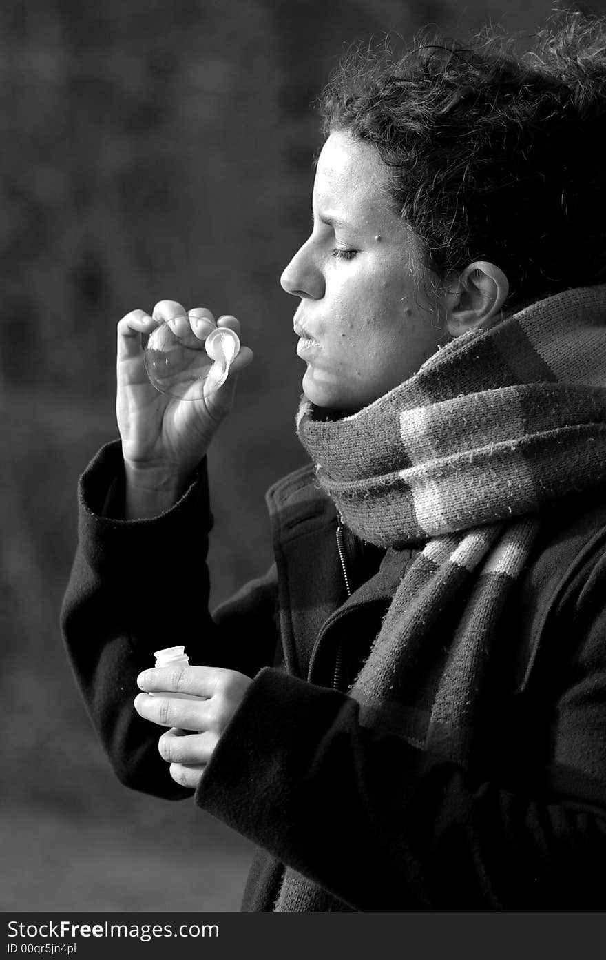 Black and white portrait of a young woman making one soap bubble. Black and white portrait of a young woman making one soap bubble.