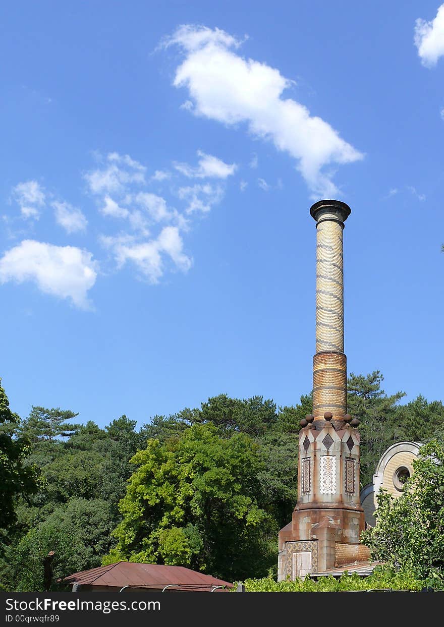 The smithy on development of clouds on a background of the blue sky with a green garden is a wonderful fairy tale. The smithy on development of clouds on a background of the blue sky with a green garden is a wonderful fairy tale