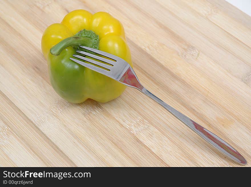 A capsicum and a fork on the floor. A capsicum and a fork on the floor