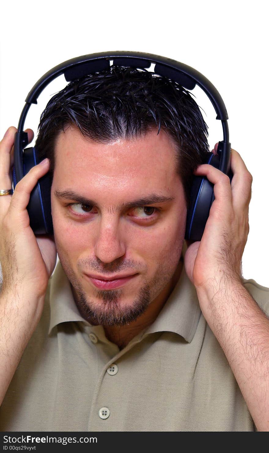 A man, wearing headphones, listening to some music, smiling. A man, wearing headphones, listening to some music, smiling