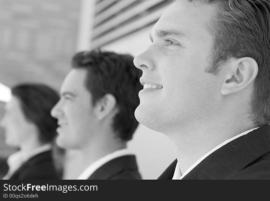 Close-up shot of three business people standing looking in same direction. Close-up shot of three business people standing looking in same direction