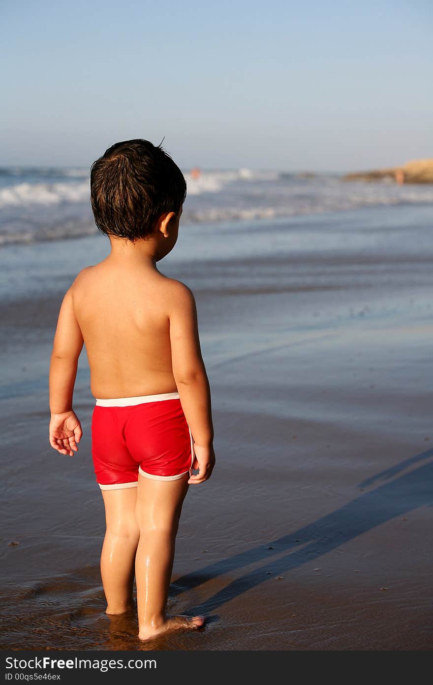 A young boy at the beach thinking what to do next. A young boy at the beach thinking what to do next