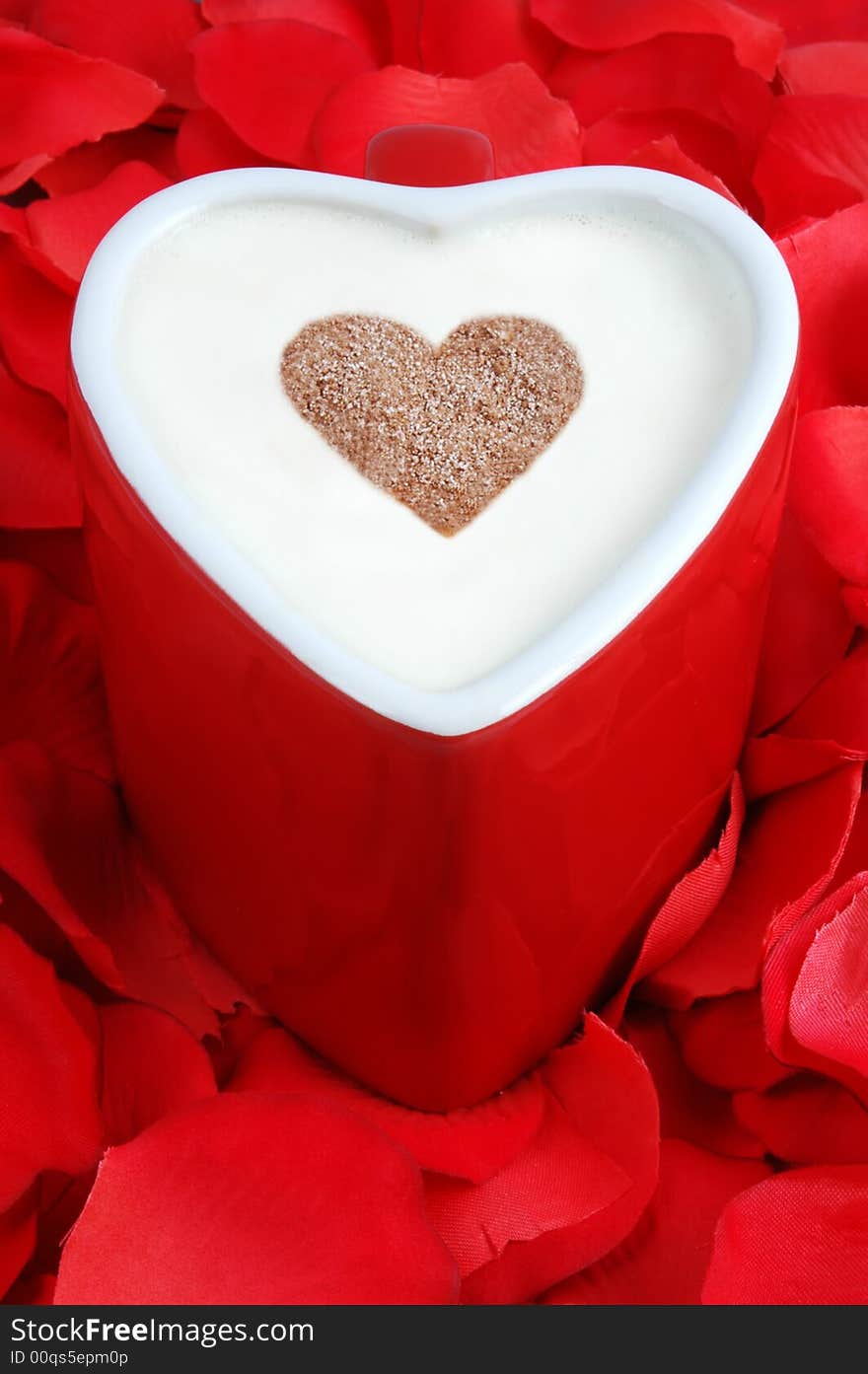 Heart shaped coffee cup on a bed of rose petals