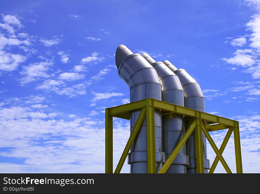 Exhausts under a blue sky with some clouds