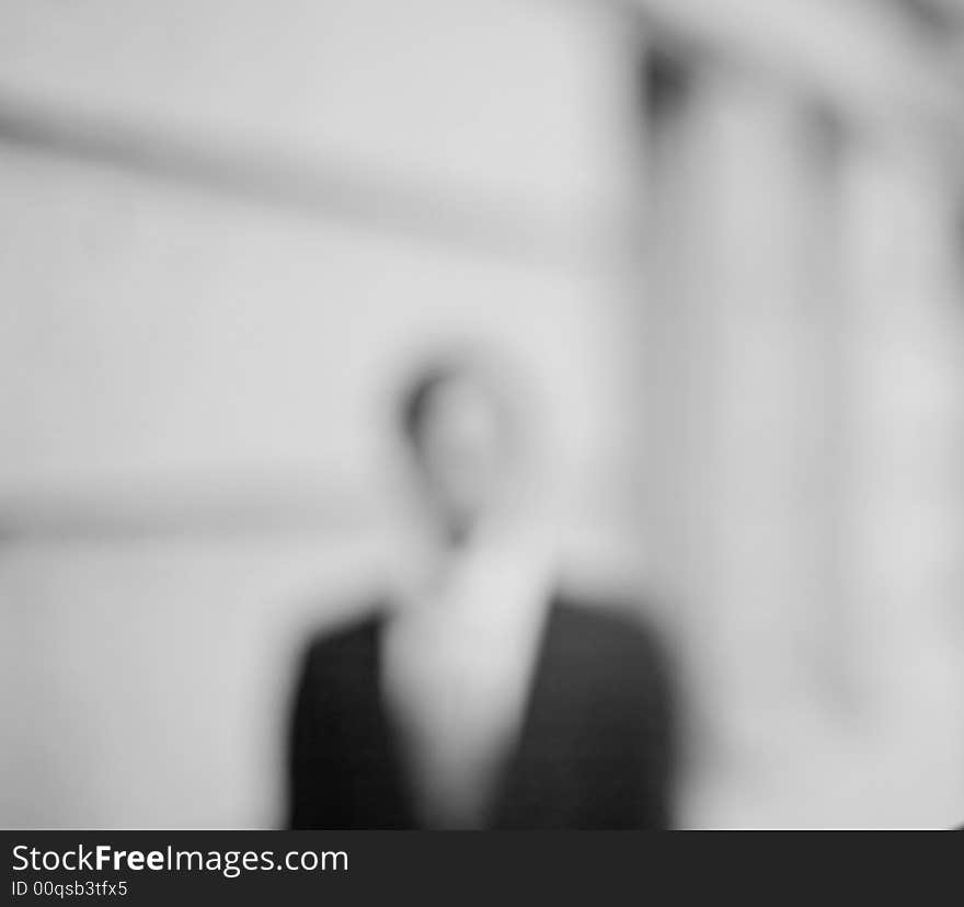 Waist-up front shot of businessman standing in front of building