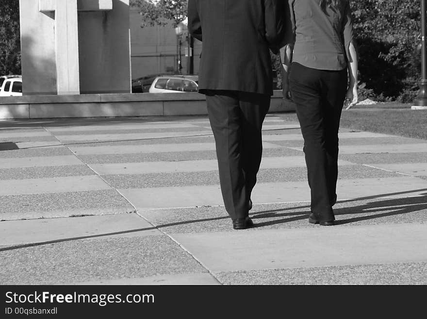 Rear view of businessman and businesswoman walking together towards building. Rear view of businessman and businesswoman walking together towards building