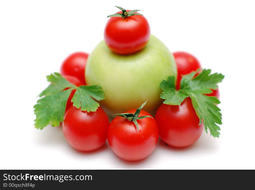 Green apple encircled by tomatoes decorated by parsley