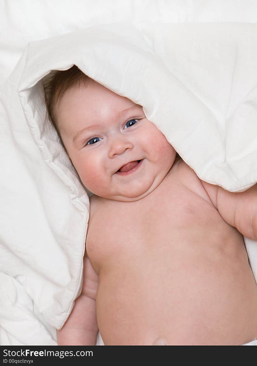 Small smiling baby on bed