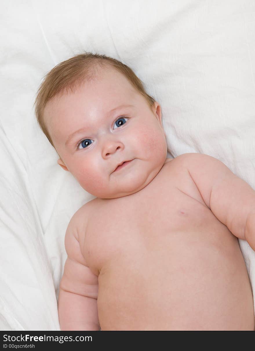 Small smiling baby on bed