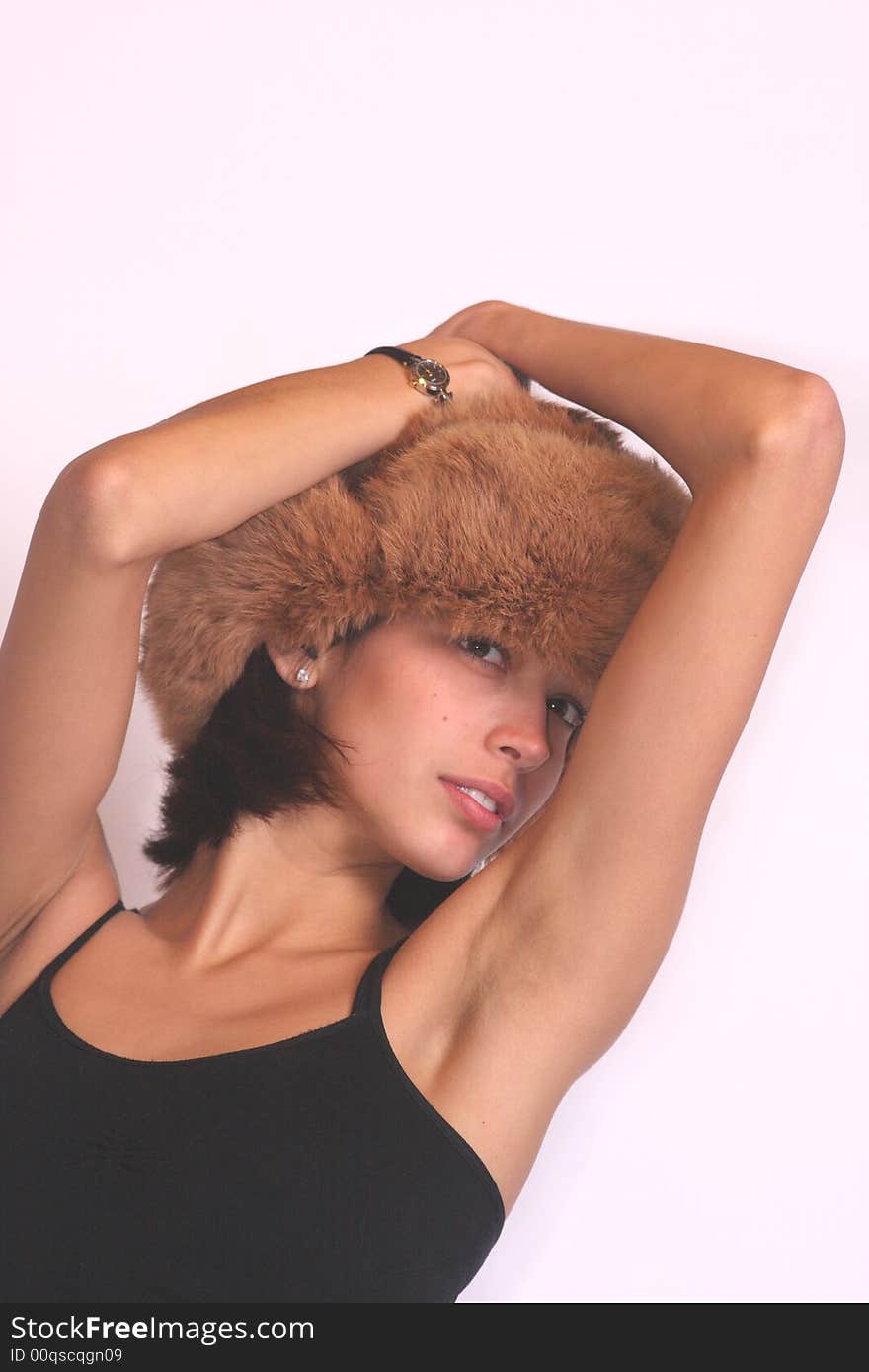 Young woman with a fur hat posing in a seductive manner. Young woman with a fur hat posing in a seductive manner