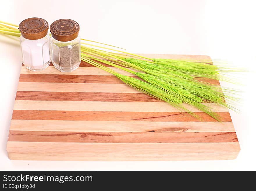 Kitchen board with pepper pot, salt and corn - copy space