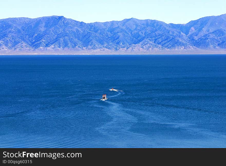 Boats are Sailing the Blue surface of Sailimu Lake. Boats are Sailing the Blue surface of Sailimu Lake