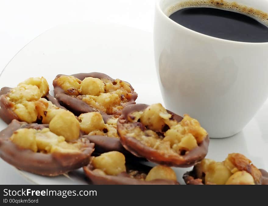 Cup of black coffee with chocolate nuts cake on white plate. Cup of black coffee with chocolate nuts cake on white plate