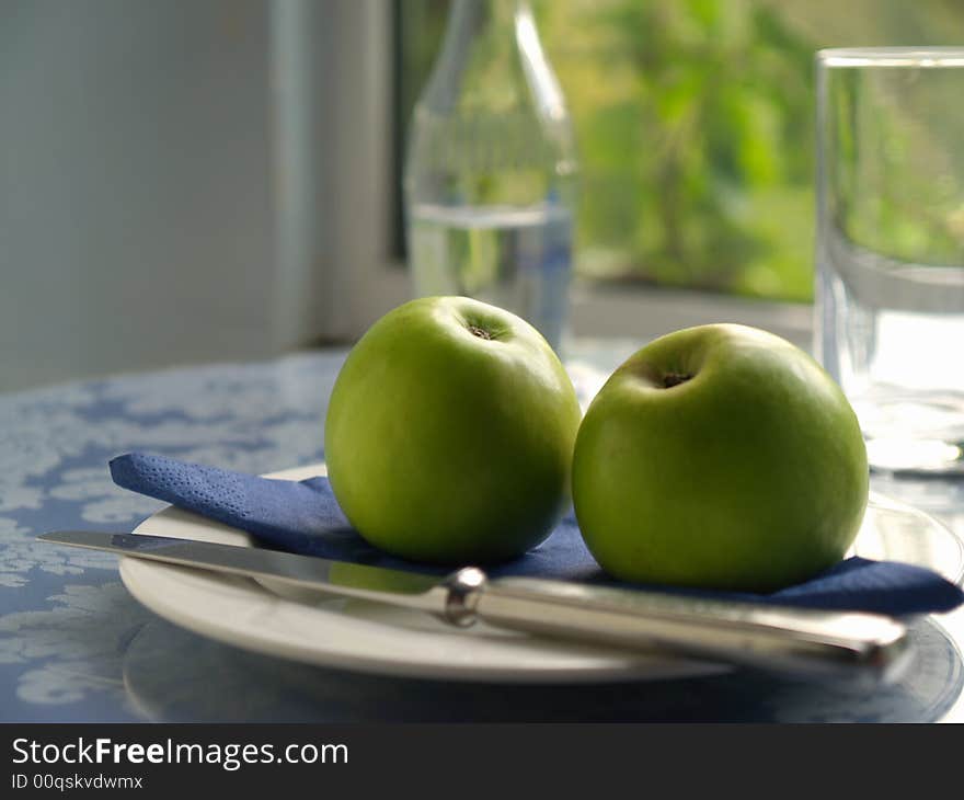 Backlit apples on plate in fromnt of sunlit window. Backlit apples on plate in fromnt of sunlit window