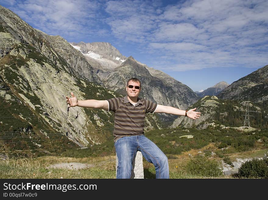 Happy man sitting beside mountains. Happy man sitting beside mountains