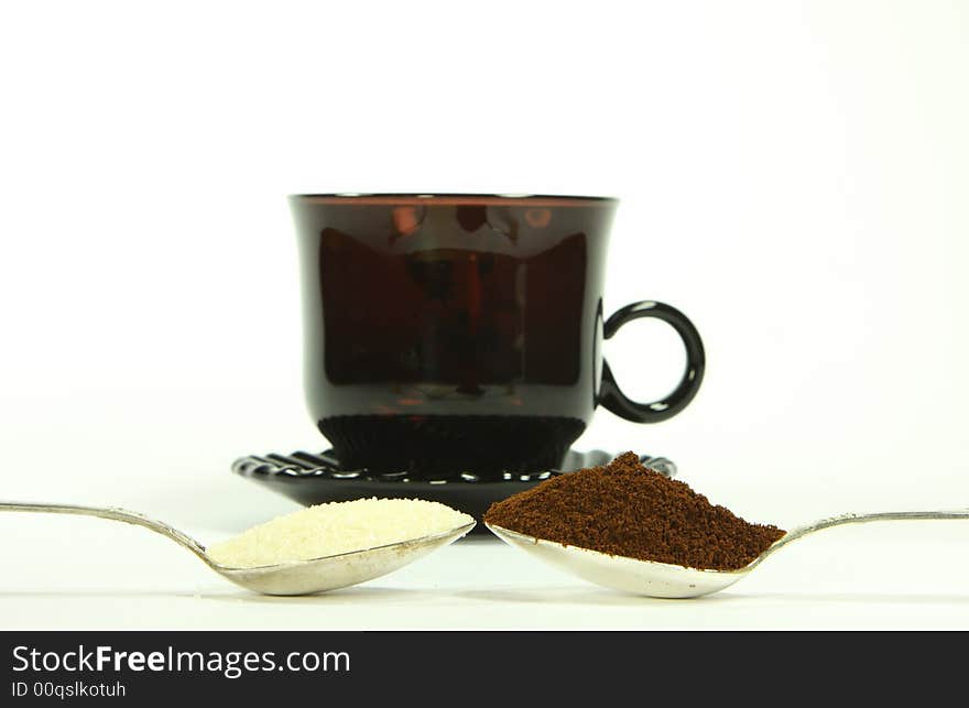 Two  tea-spoon with coffee and sugar infront of coffee-cup. Two  tea-spoon with coffee and sugar infront of coffee-cup