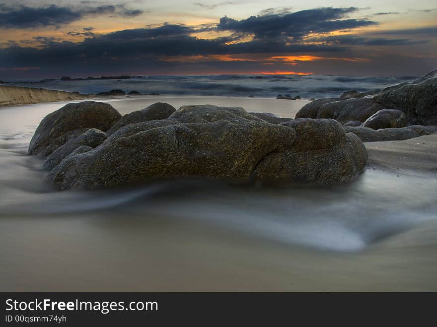 A rock in the water at sunset. A rock in the water at sunset