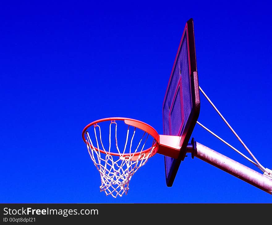 Basket ball net and ring from the side against blue sky. Basket ball net and ring from the side against blue sky