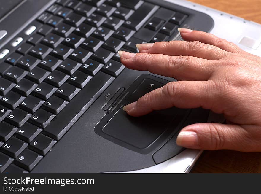 Mid age woman's hands on the keyboard of laptop in the office. Mid age woman's hands on the keyboard of laptop in the office