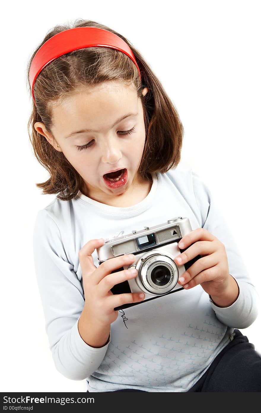 A young girl looking surprised an old camera. Isolation on white. A young girl looking surprised an old camera. Isolation on white.