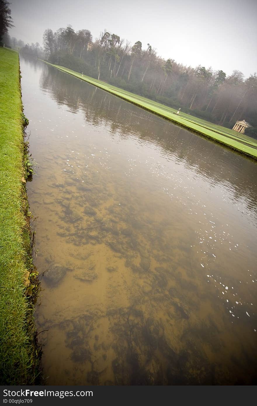 Water reflections at Fountains Abbey in North Yorkshire, old broken down abbey and surrounding grounds