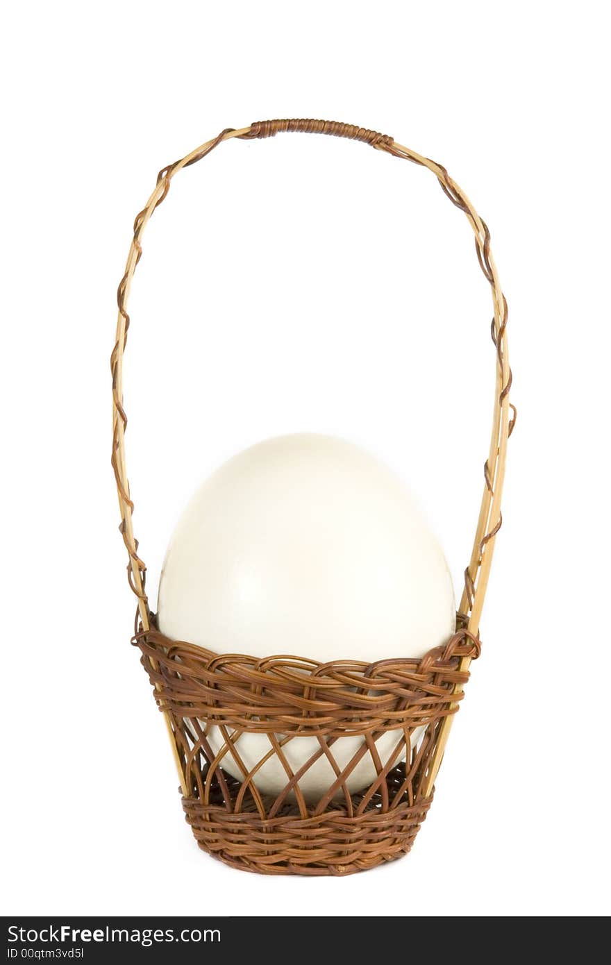 Ostrich egg in a wicker basket on white background