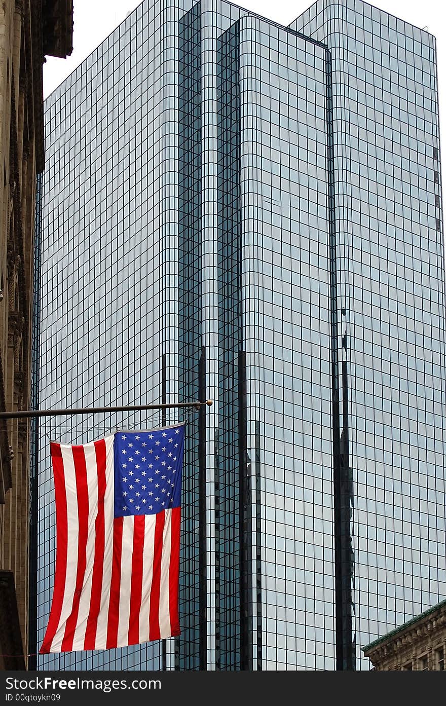 A US flag hanging in front of a large glass skyscraper. Taken in Boston. A US flag hanging in front of a large glass skyscraper. Taken in Boston.