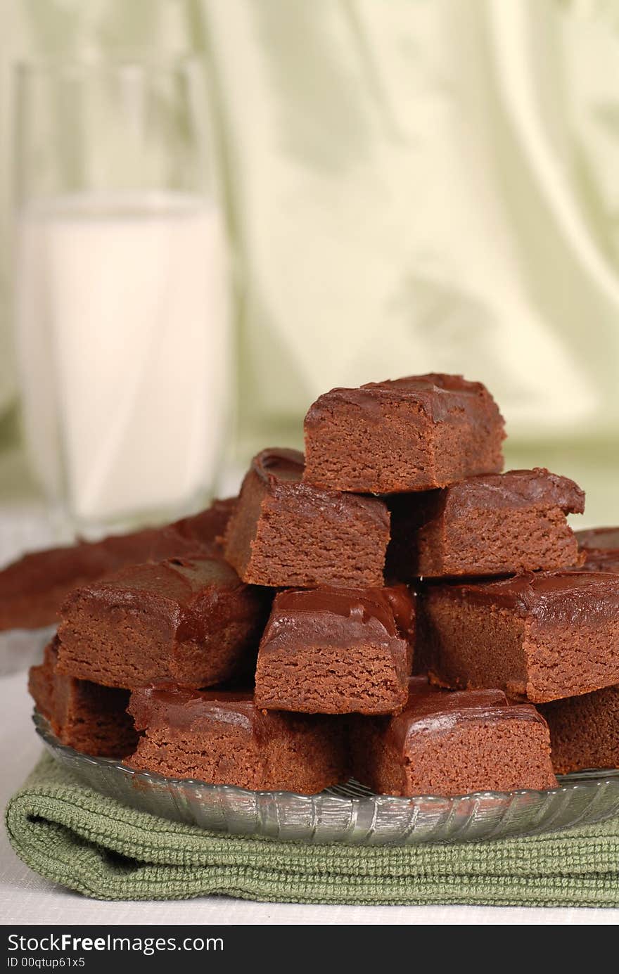 Plate of chocolate brownies with a glass of milk