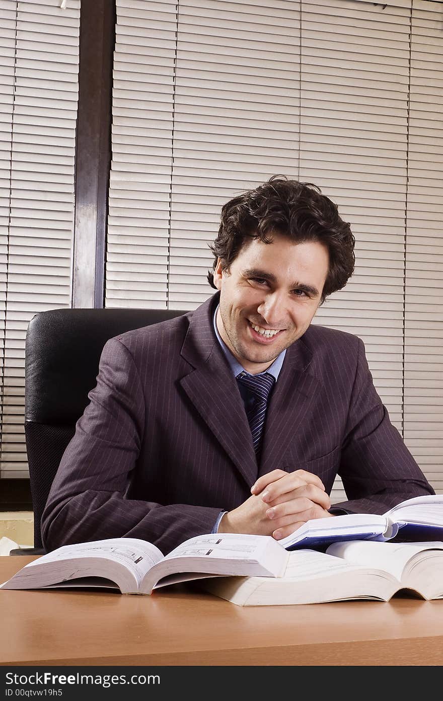 Business man at office with many books