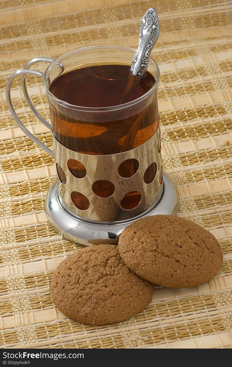 Hot black tea in glass with two cookies. Hot black tea in glass with two cookies