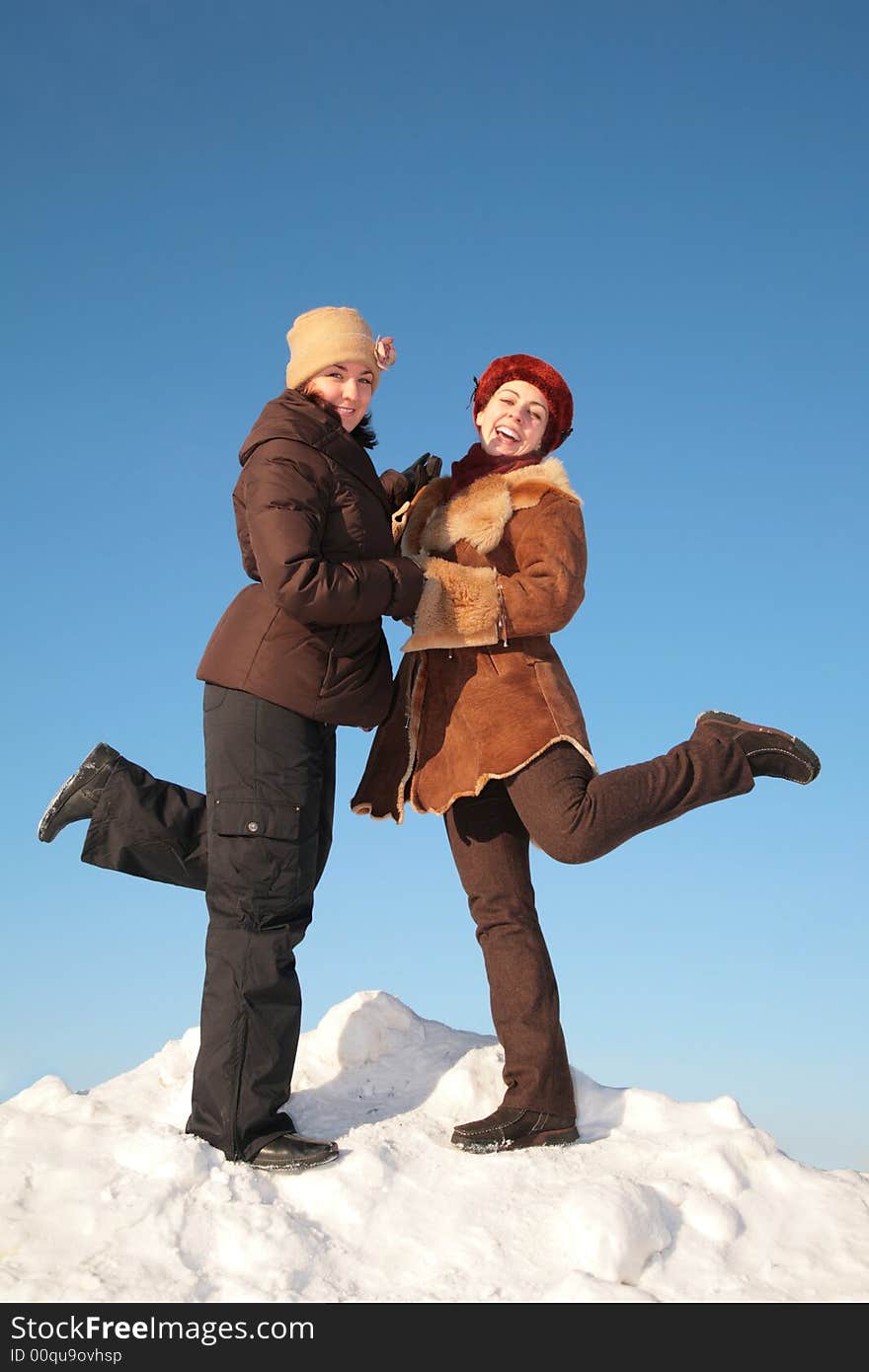 Two young woman posing on snow hill