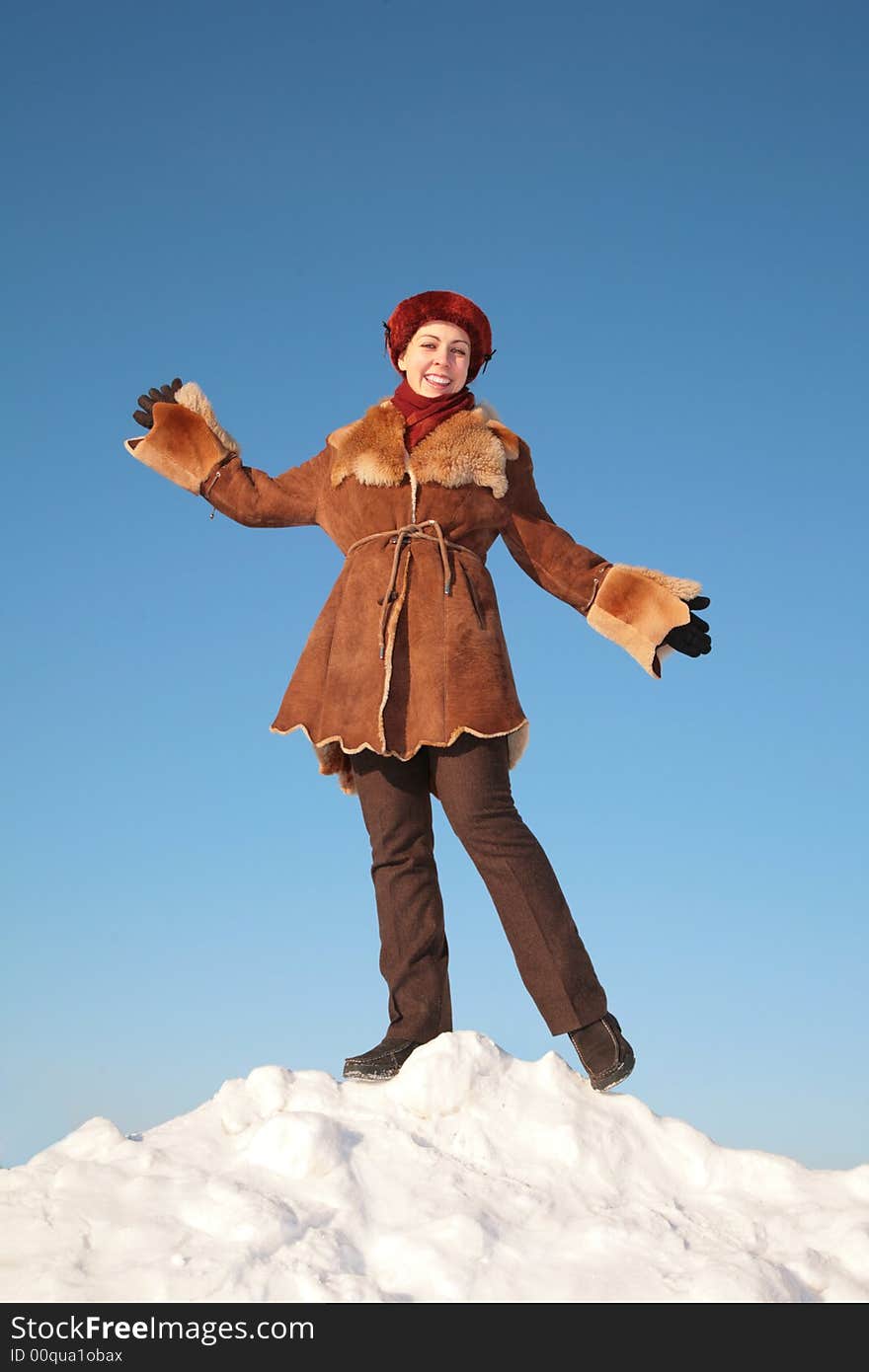 Pretty young woman posing on snow hill