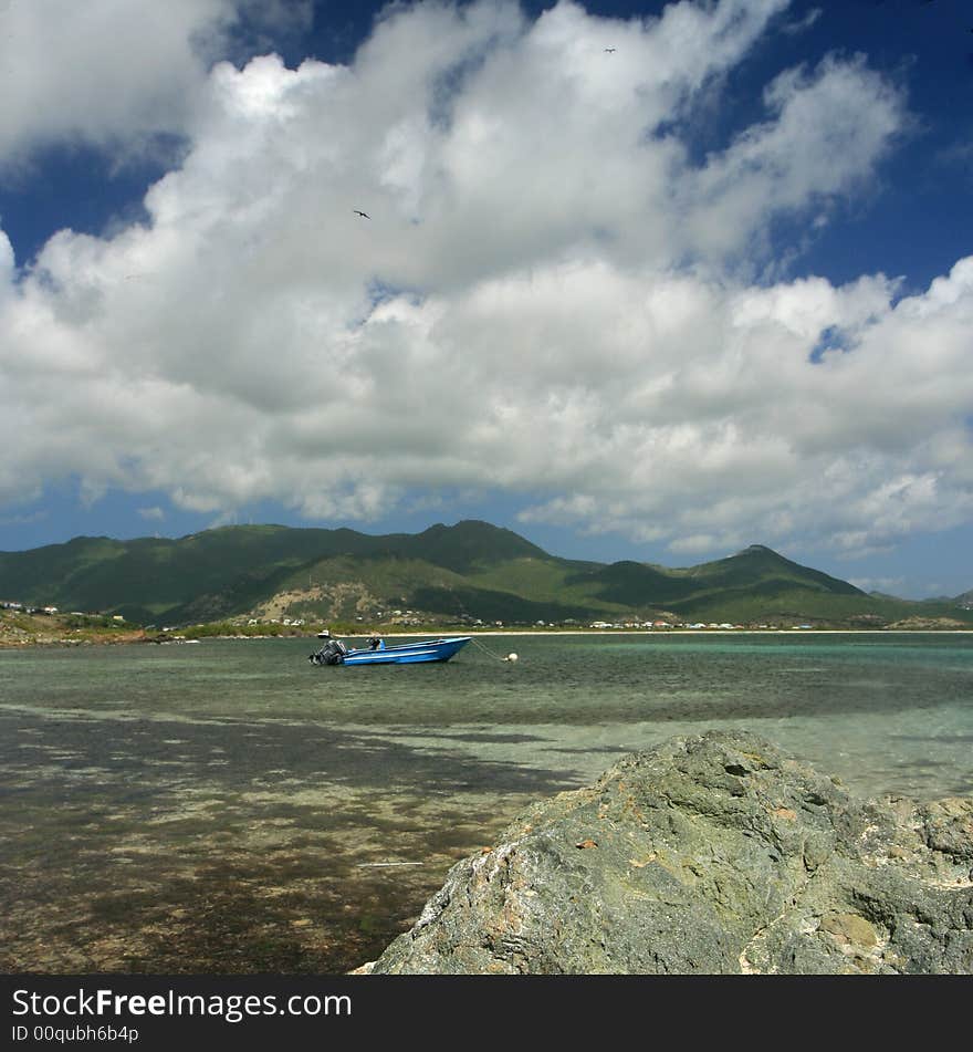 A small boat floats in the waters off Coconut Grove, St. Maarten. A small boat floats in the waters off Coconut Grove, St. Maarten.