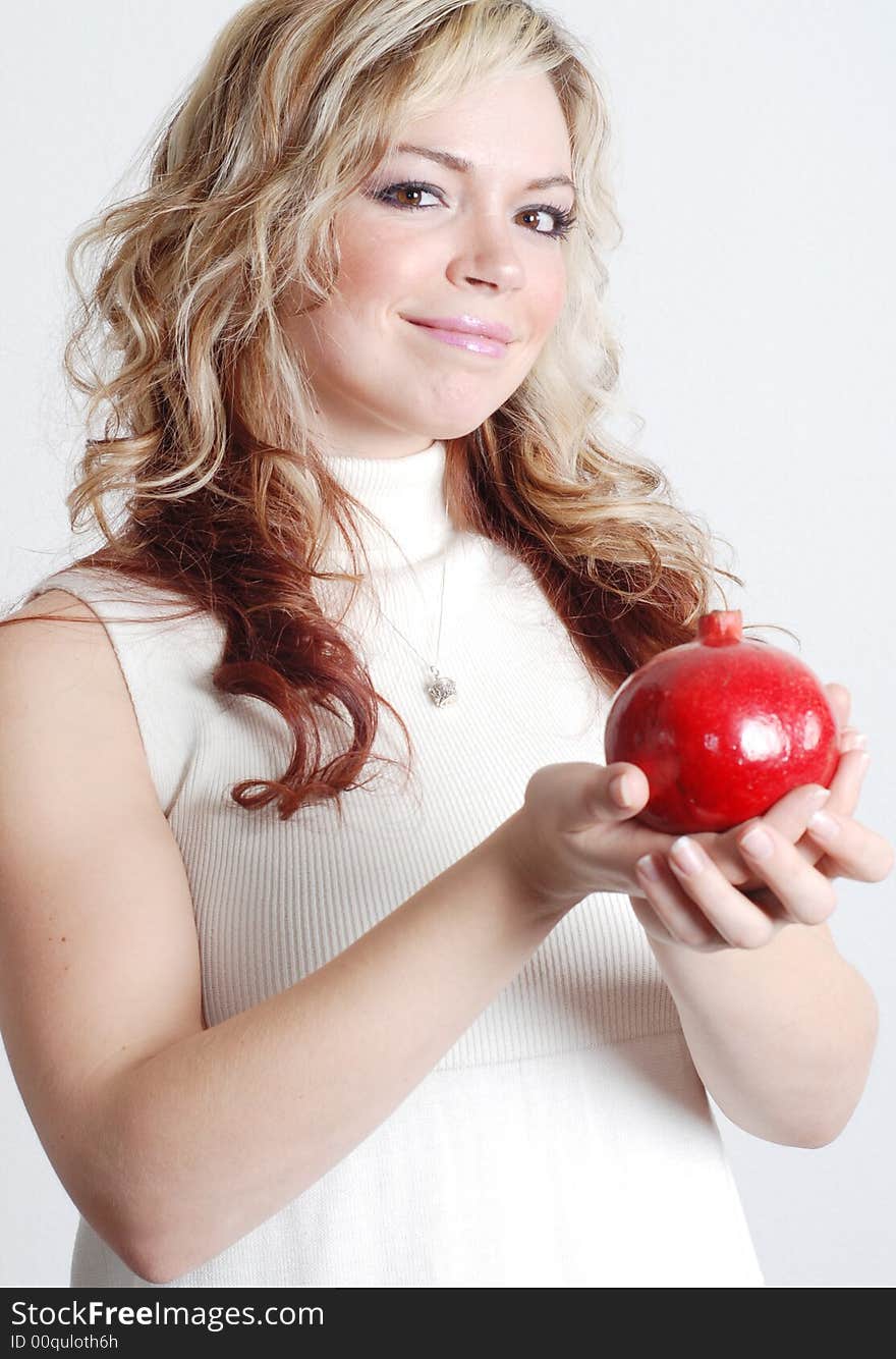 Beautiful woman is holding a fruit in her hands. Beautiful woman is holding a fruit in her hands