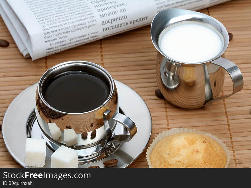 Cup of black coffee with muffin and milk