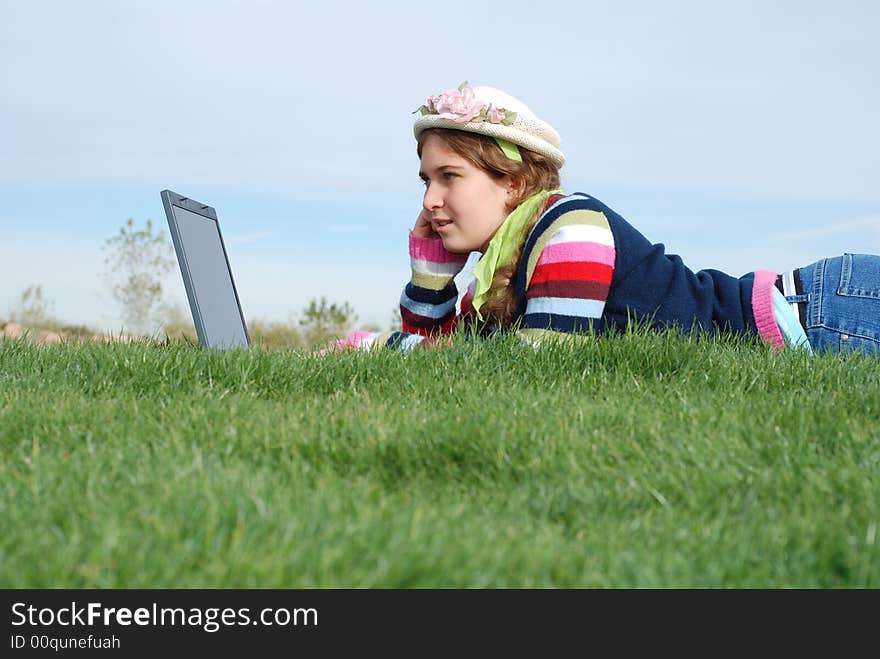 Young girl is working on laptop at outdoor location. Young girl is working on laptop at outdoor location