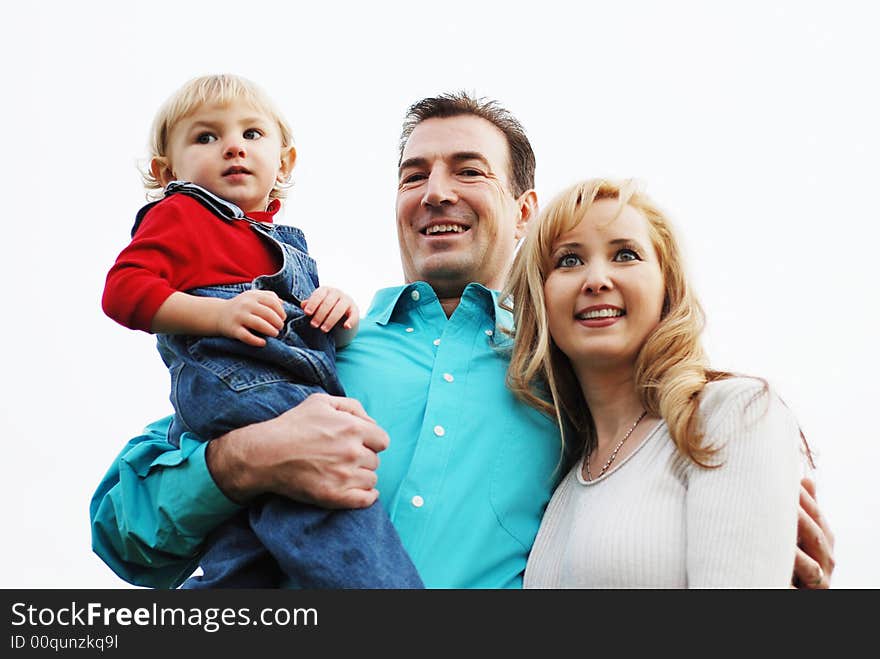 Happy couple with a child enjoying their time together(The man is in focus, woman and the kid is slightly out of focus)