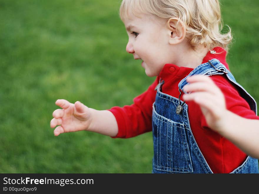 A little kid is enjoying his time in the park(focus is not perfect, motion blur). A little kid is enjoying his time in the park(focus is not perfect, motion blur)