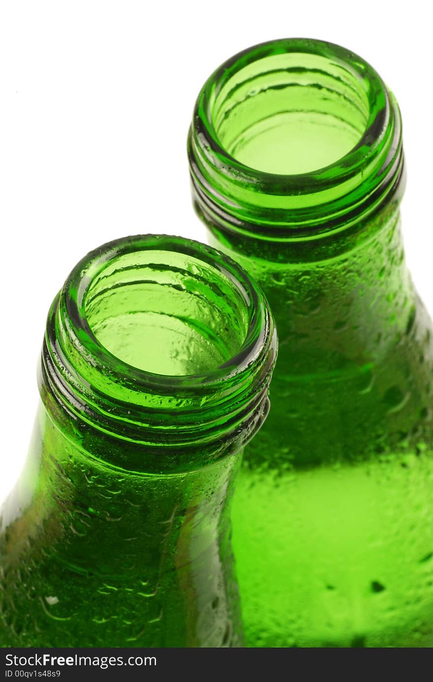 Bottled water in green, condensation-covered bottles; differential focus