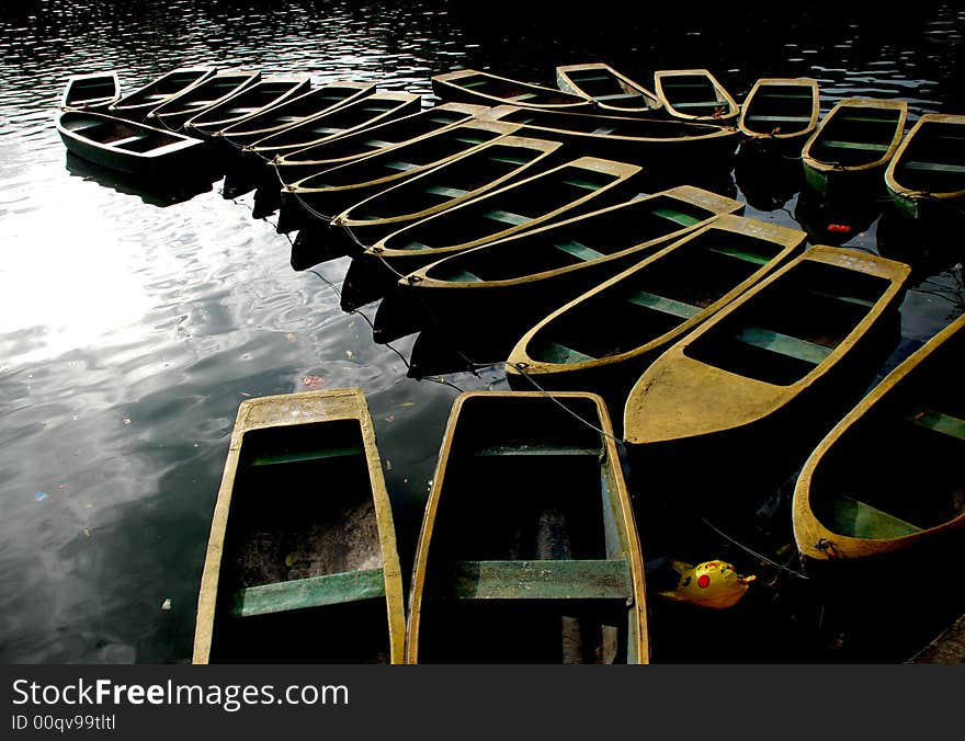 Lines of boats anchoring in the berth of a park lake. Lines of boats anchoring in the berth of a park lake.