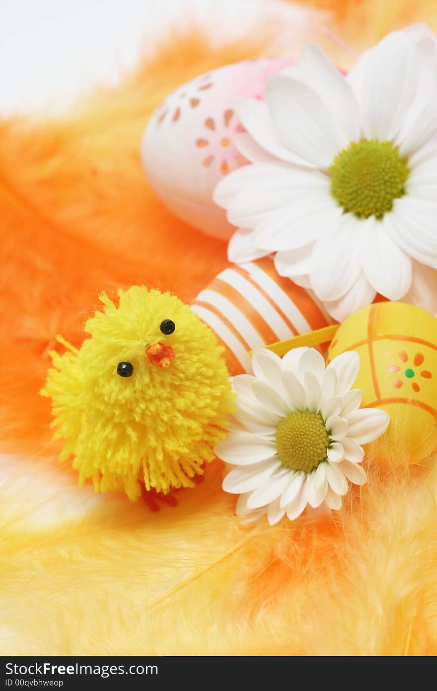 Easter motive-little chick,white flover,easter eggs on yellow and orange feathers.