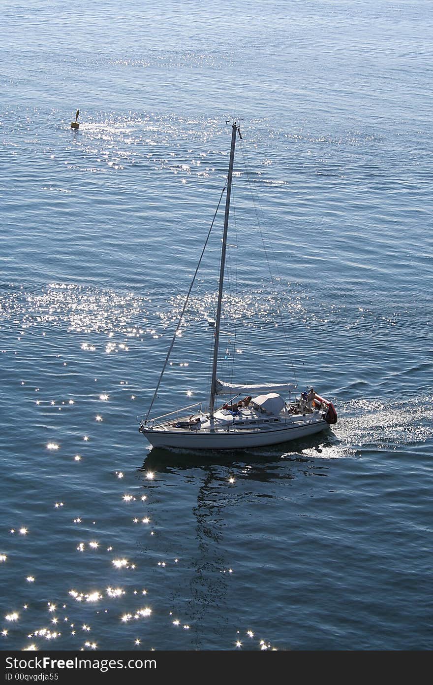 A sail boat on Fehmarn Sund seen from the bridge. A sail boat on Fehmarn Sund seen from the bridge