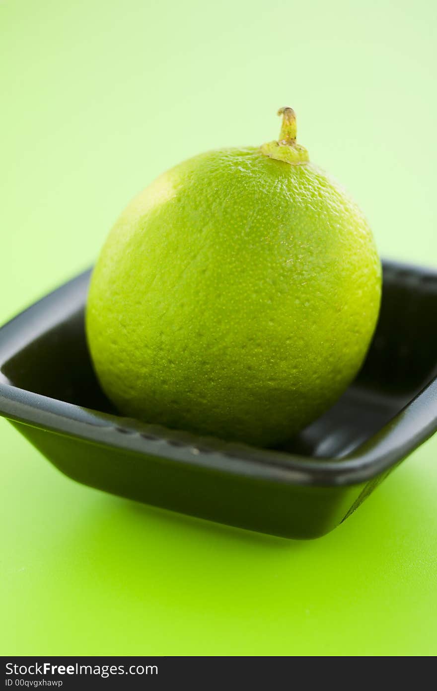 Lime in the small cup over light green background